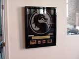Award plaque from the game's publisher, Acclaim, for the success of Mortal Kombat for home systems.